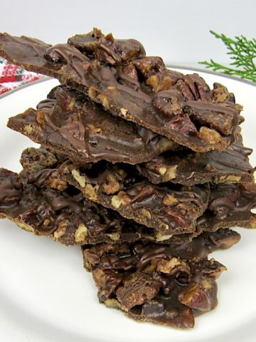 Pecan Praline Bark pieces stacked up on white plate