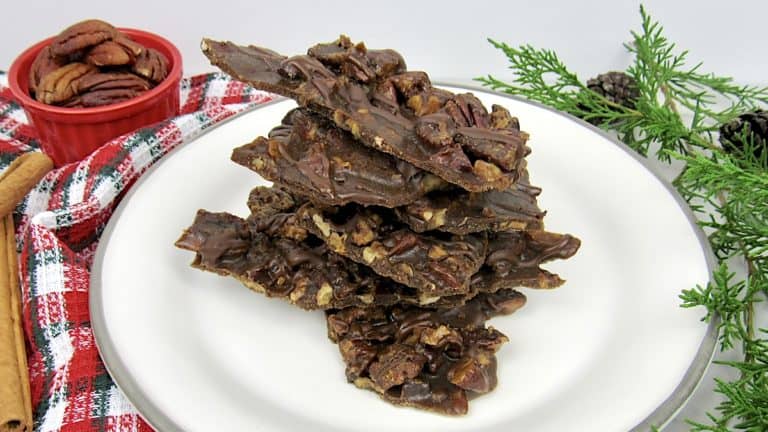 Pecan Praline Bark pieces stacked up on white plate