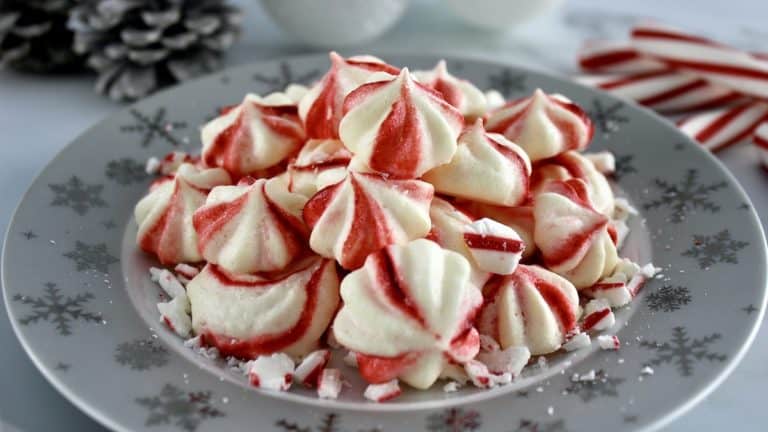 Peppermint Meringue Cookies piled up on gray snowflake plate