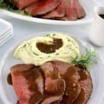 Roast Beef with Gravy on plate with mashed cauliflower and gravy with roast in back