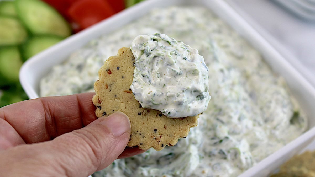 holding up cracker dipped in Spinach Dip