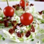 Wedge Salad Bites on white plate with cherry tomato through toothpick