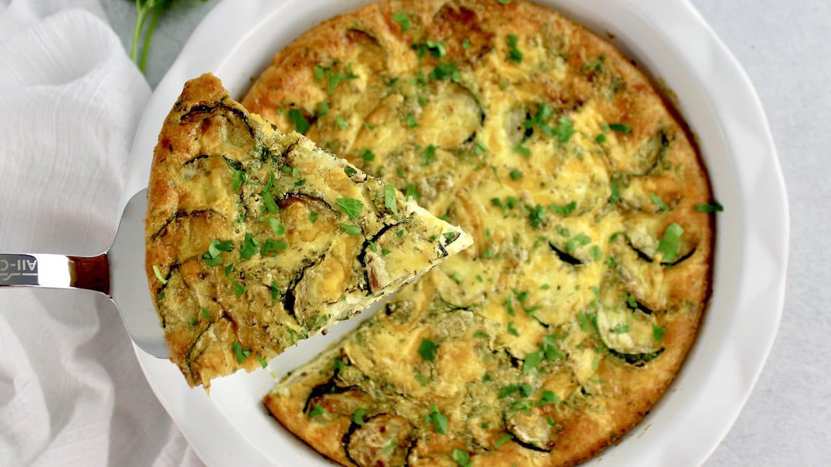 Crustless Zucchini Quiche with slice being held up