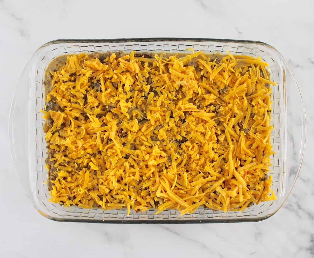 Bacon Cheeseburger Casserole with shredded cheese on top unbaked