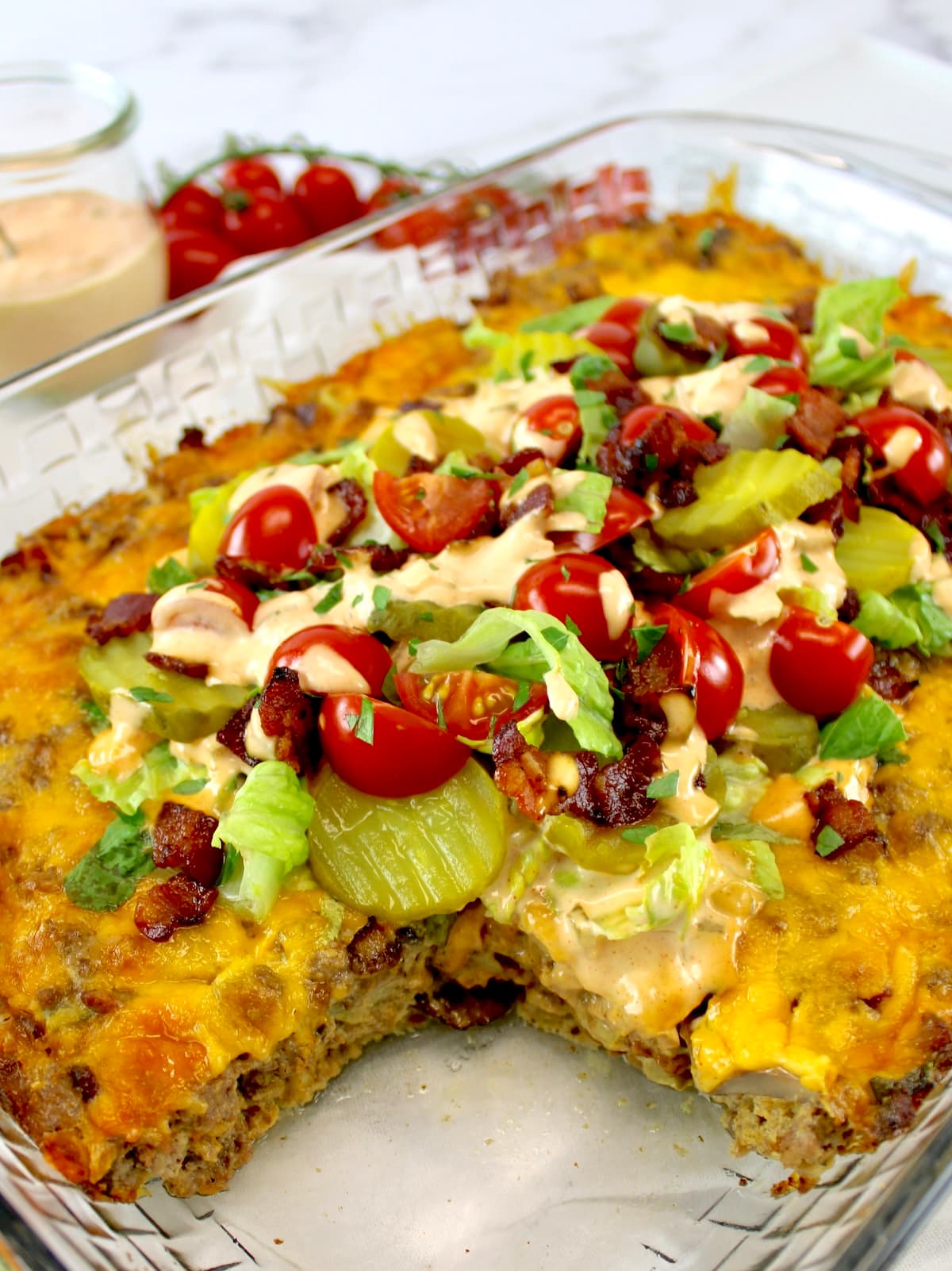 Bacon Cheeseburger Casserole with lettuce, tomatoes and pickles on top