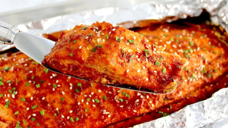 closeup of Asian Glazed Salmon on white plate with chopped chives
