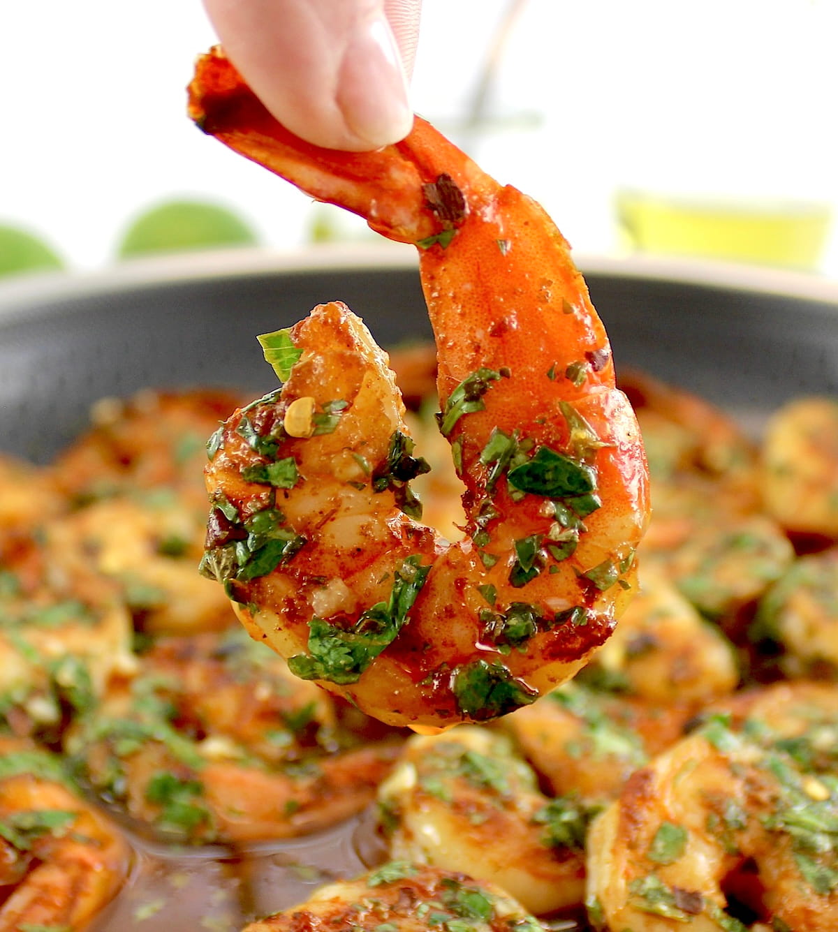 holding up Chimichurri Shrimp over skillet