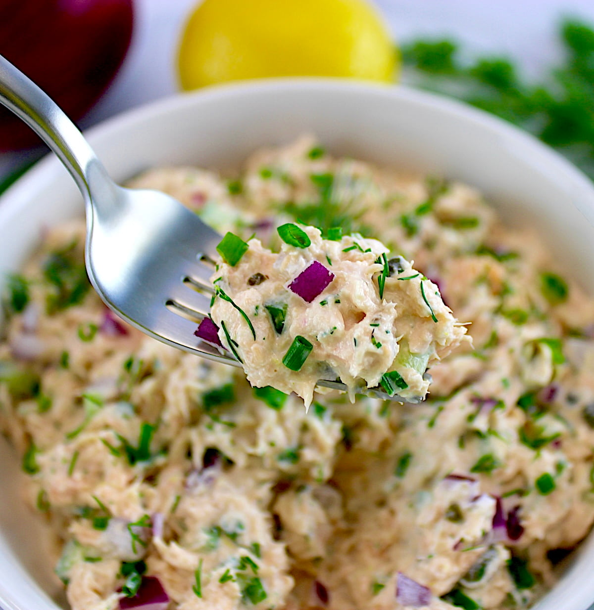 fork full of Creamy Dill Salmon Salad held up over white bowl