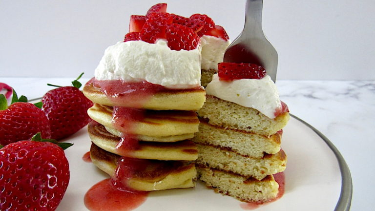 Keto Fluffy Pancakes with Strawberry Sauce with bite cut with fork