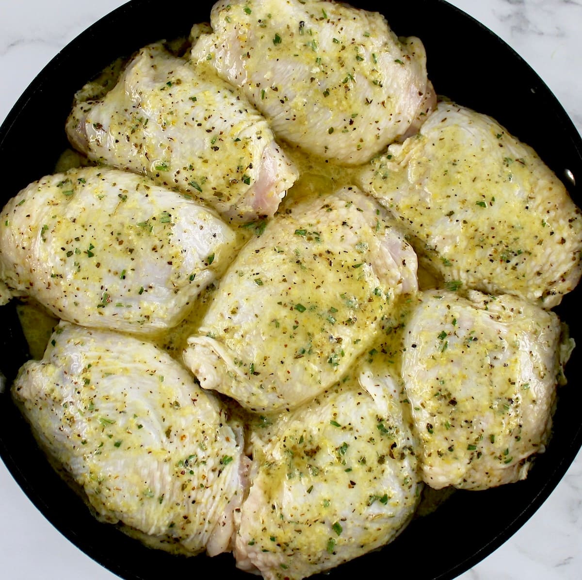 8 chicken thighs in skillet with marinade poured over top