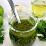 Chimichurri Sauce in open glass jar with spoon