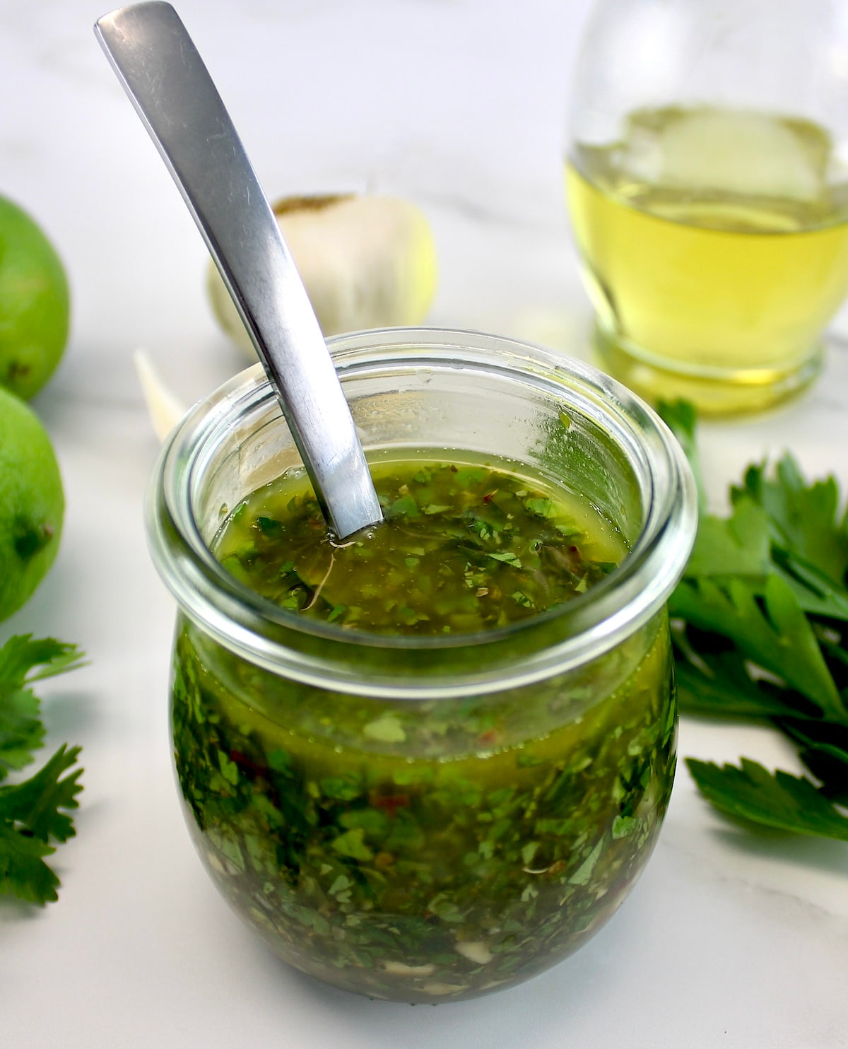 Chimichurri Sauce in open glass jar with spoon