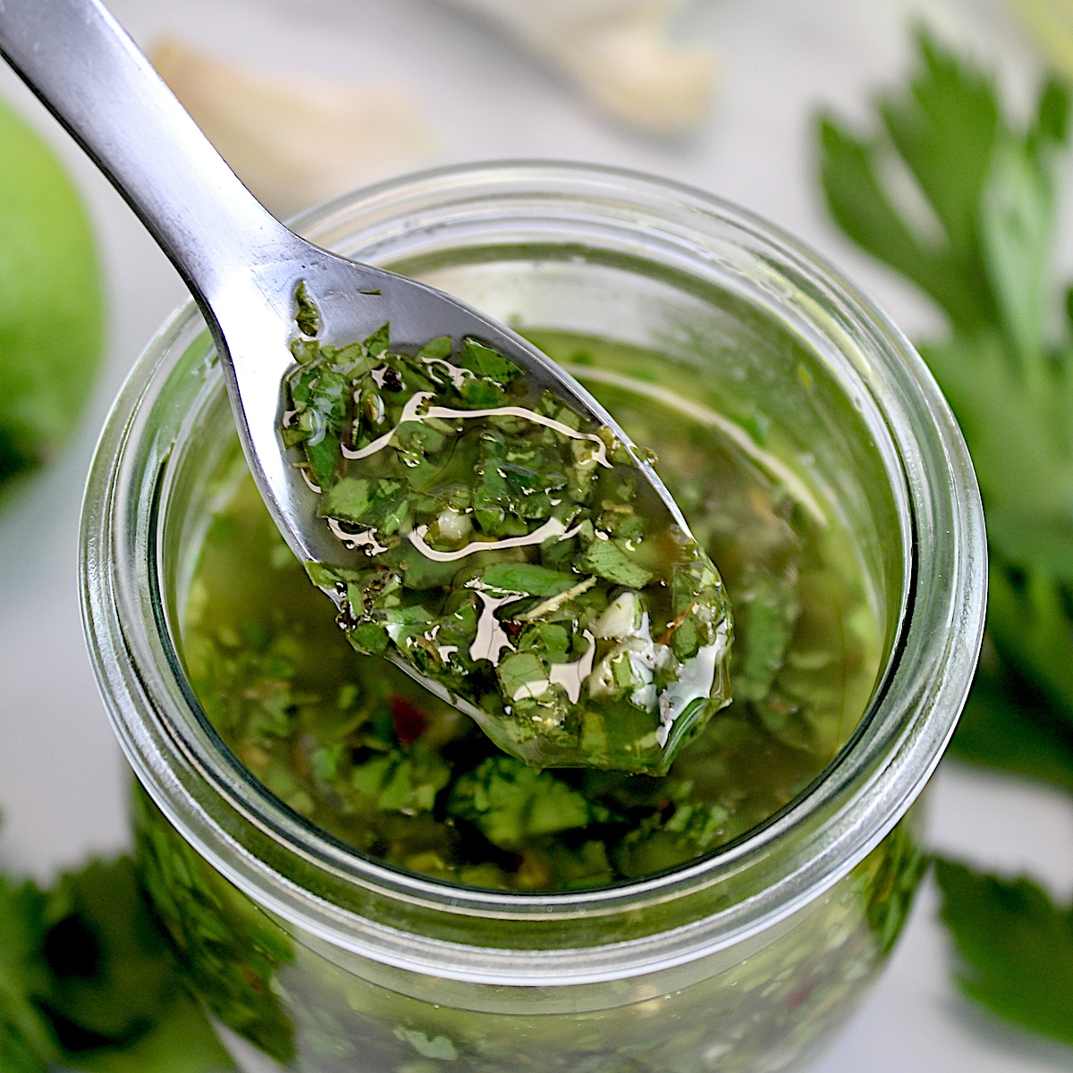 Chimichurri Sauce being spooned out of glass jar