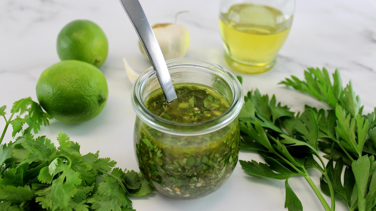 Chimichurri Sauce in open glass jar with spoon