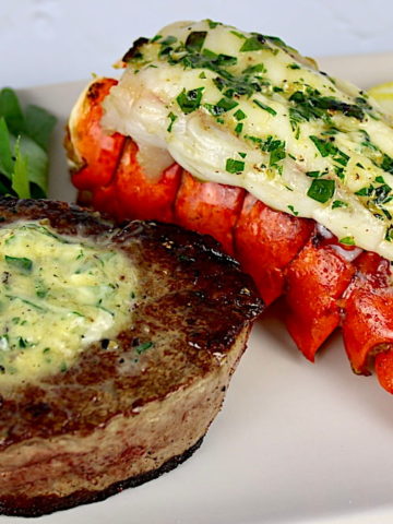 filet mignon with herb butter on top and lobster tail on side