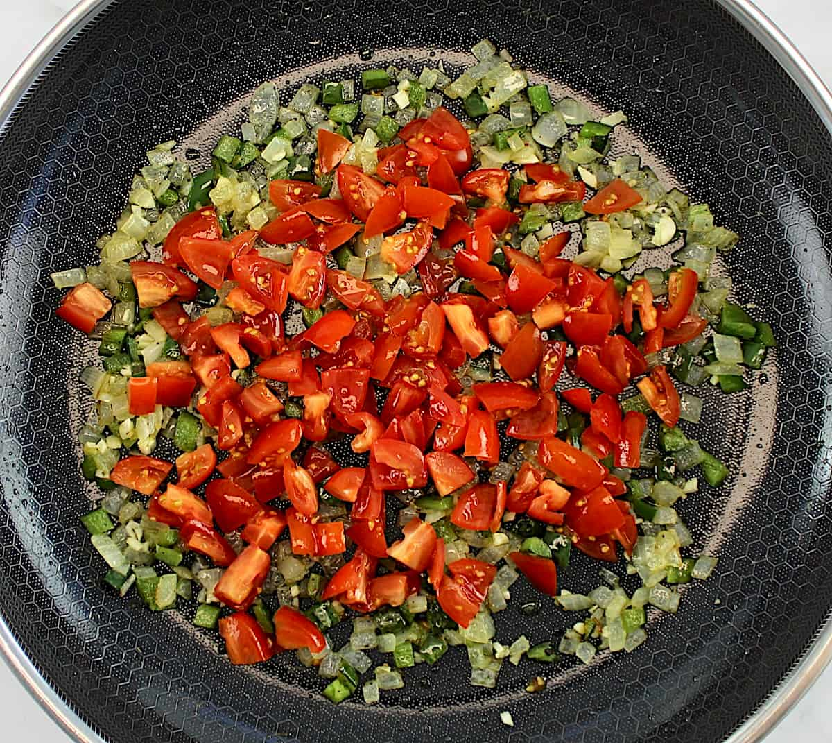 diced onions, tomatoes and jalapeño peppers in skillet