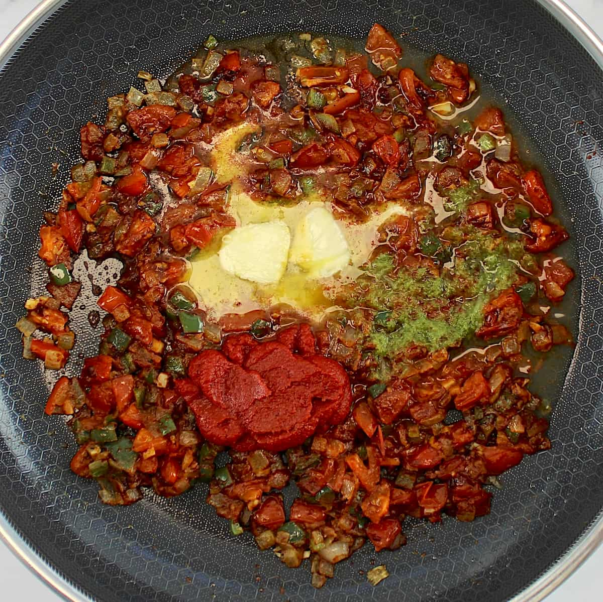 diced onions, tomatoes and jalapeño peppers in skillet with butter, lime and tomato paste