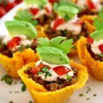 Mini Taco Bites on white platter with avocado piece on top