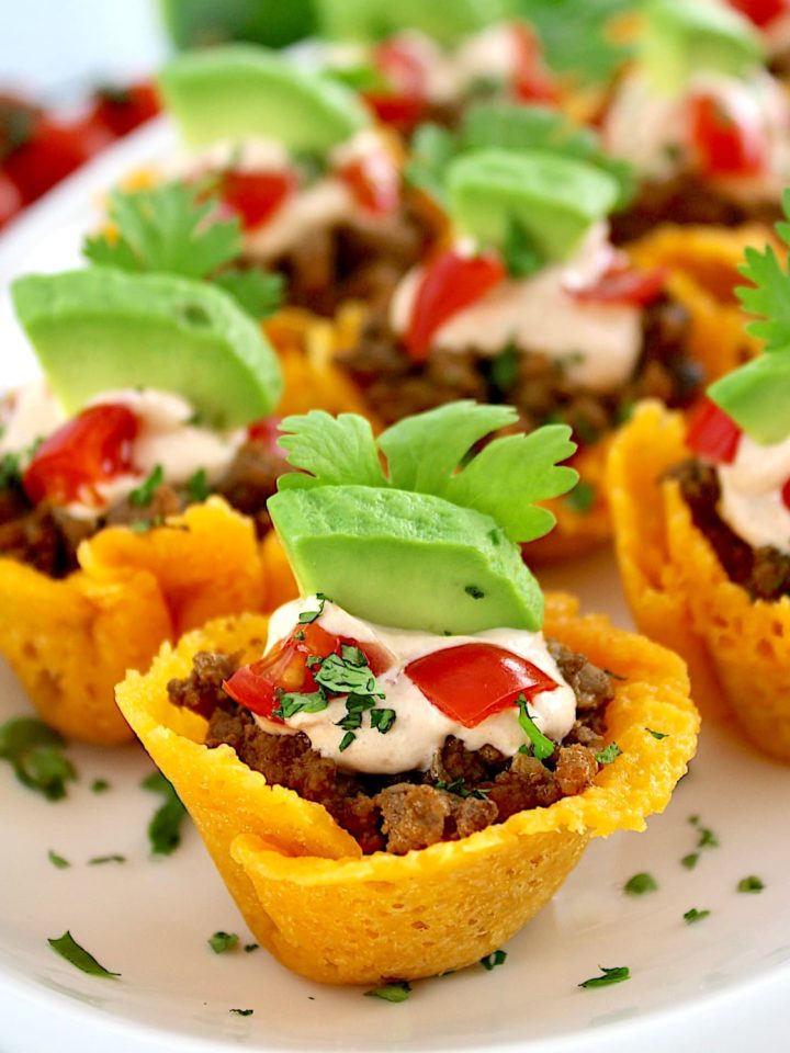 Mini Taco Bites on white platter with avocado piece on top