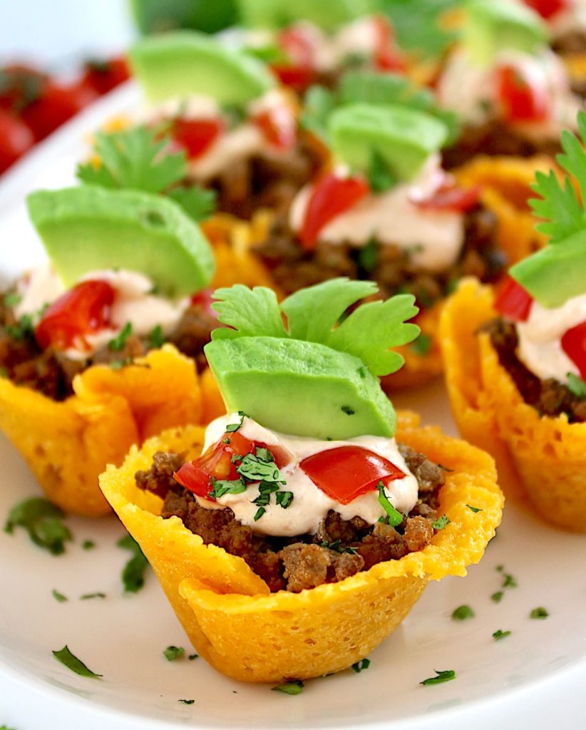 Mini Taco Bites on white platter with avocado piece on top