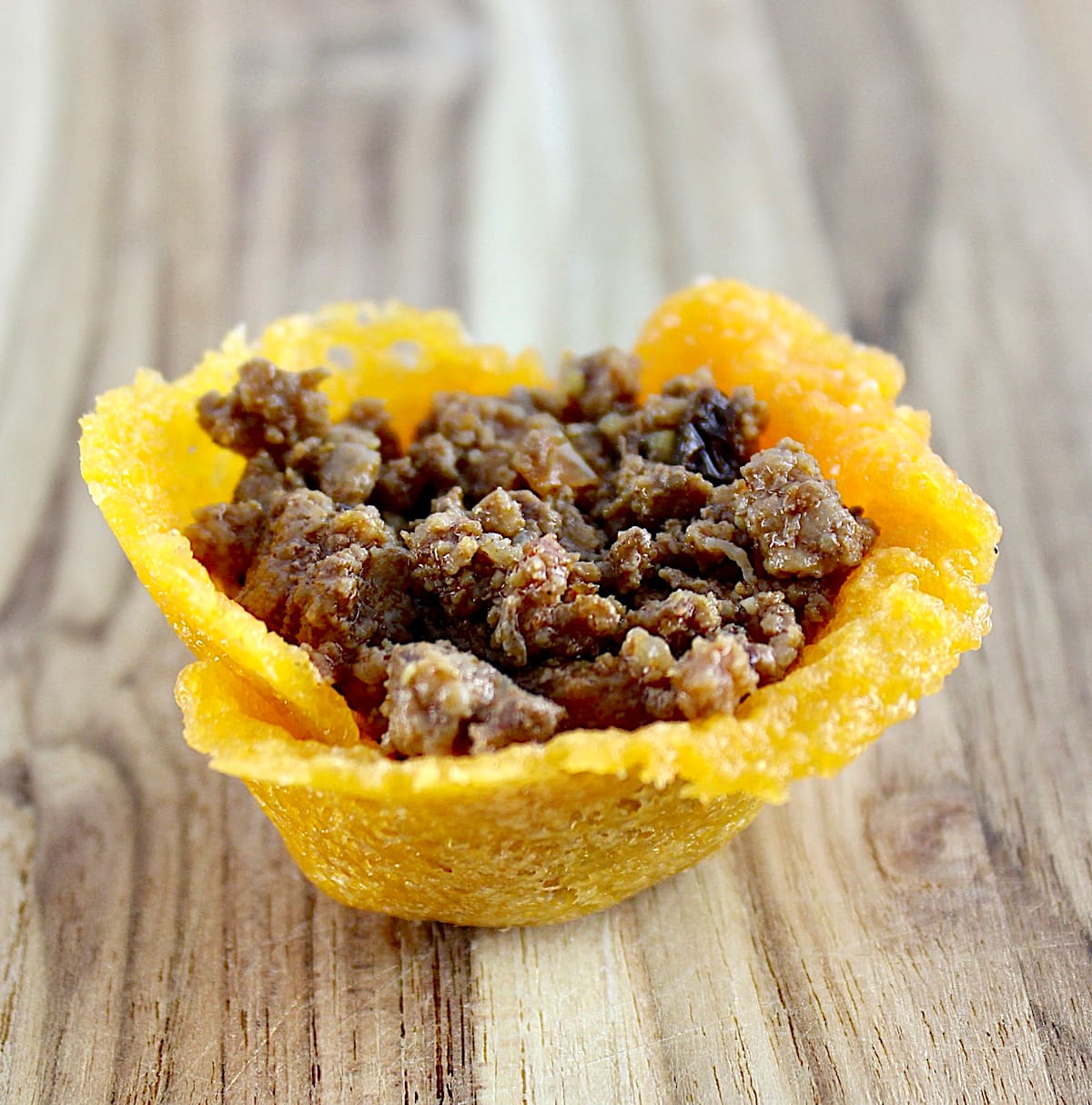 cheddar cheese cup with taco meat on cutting board