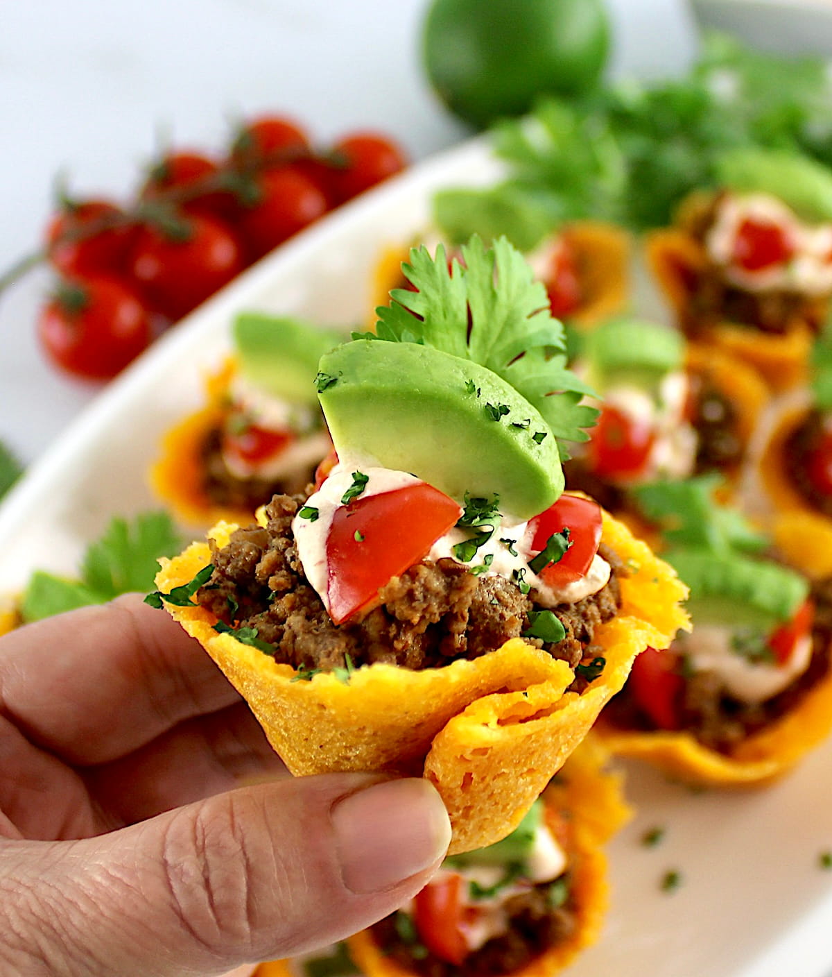 holding up Mini Taco Bite with more in background