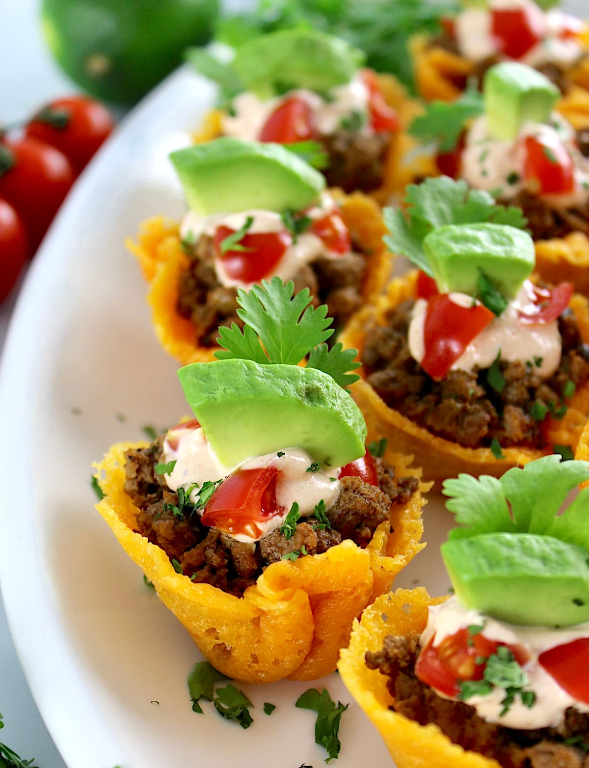 closeup of Mini Taco Bites on white platter with avocado and cilantro on top