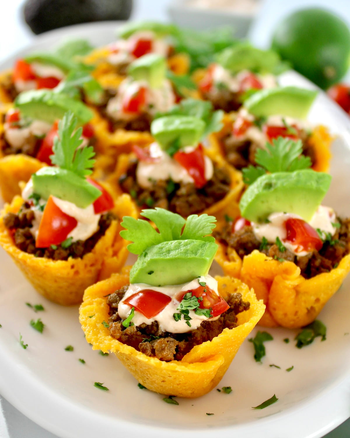 Mini Taco Bites on white platter with avocado piece on top