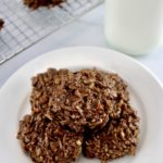 No-Bake Keto Cookies on white round plate with glass milk bottle in back