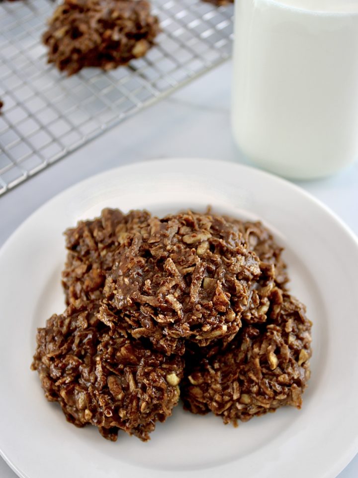 No-Bake Keto Cookies on white round plate with glass milk bottle in back