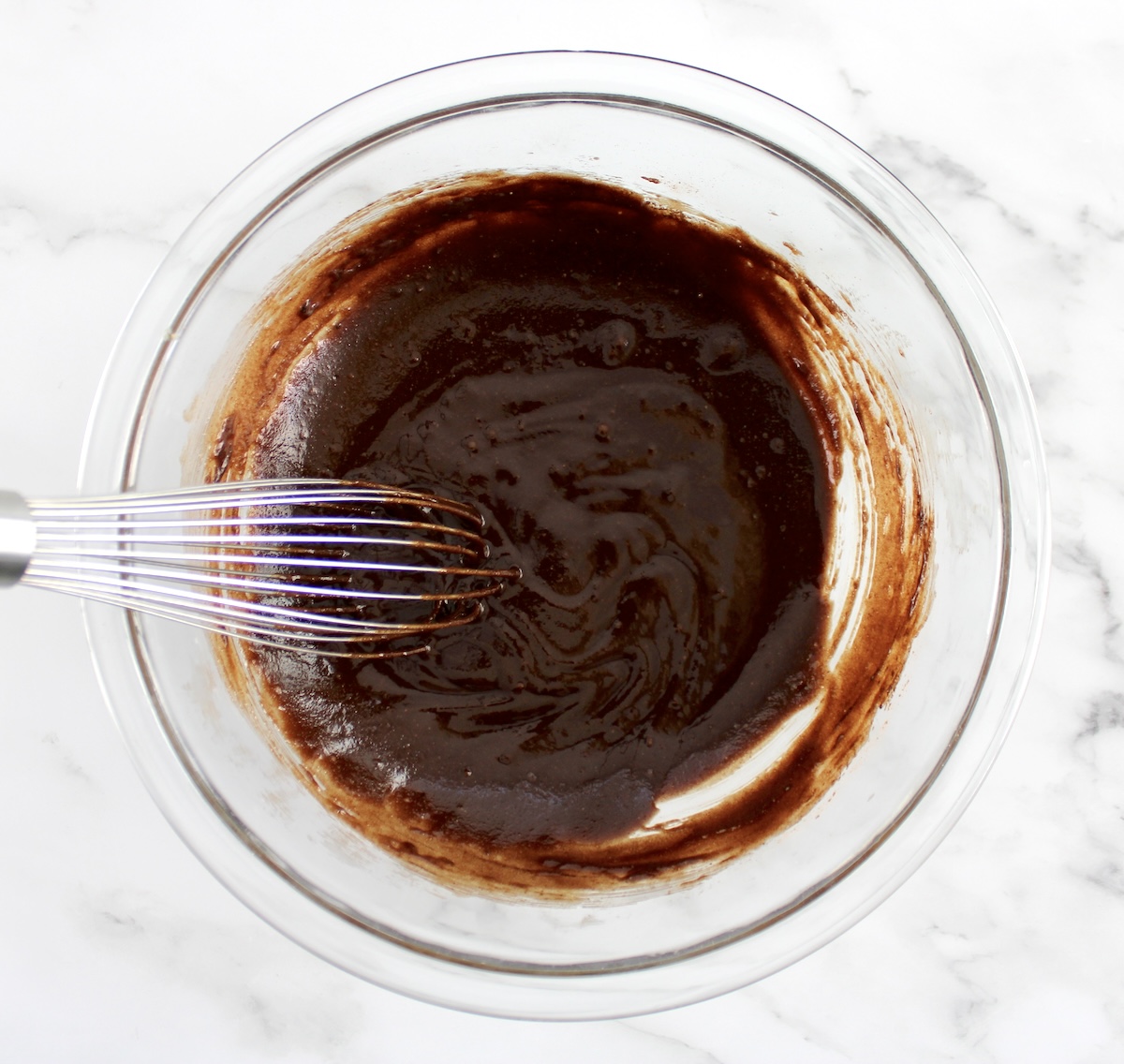 melted chocolate cookie mix in glass bowl with whisk