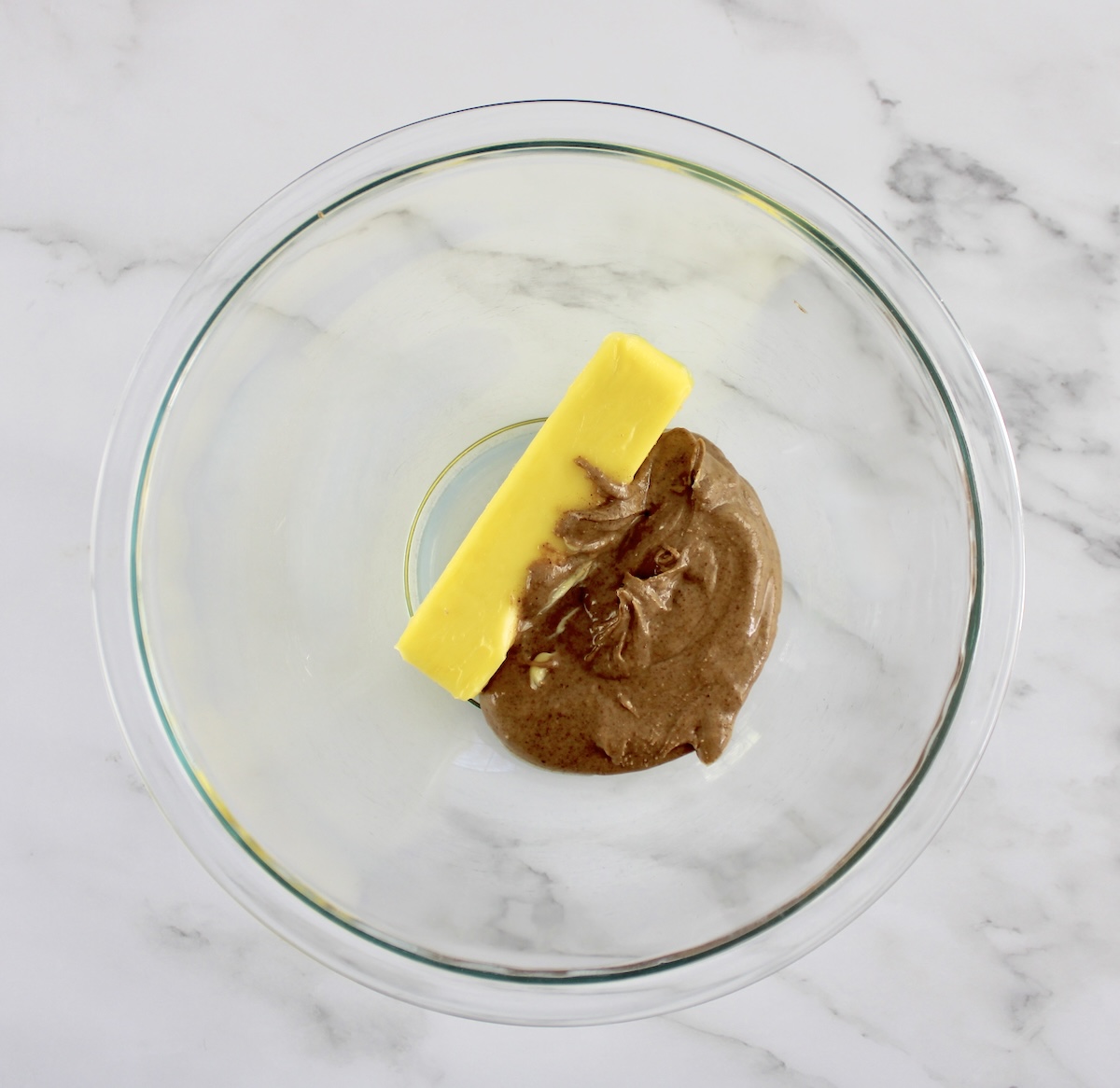 stick of butter and almond butter in glass bowl