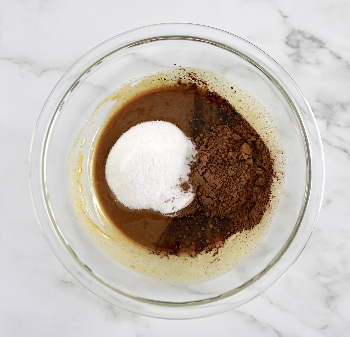 melted butter, cocoa powder and sweetener in glass bowl unmixed