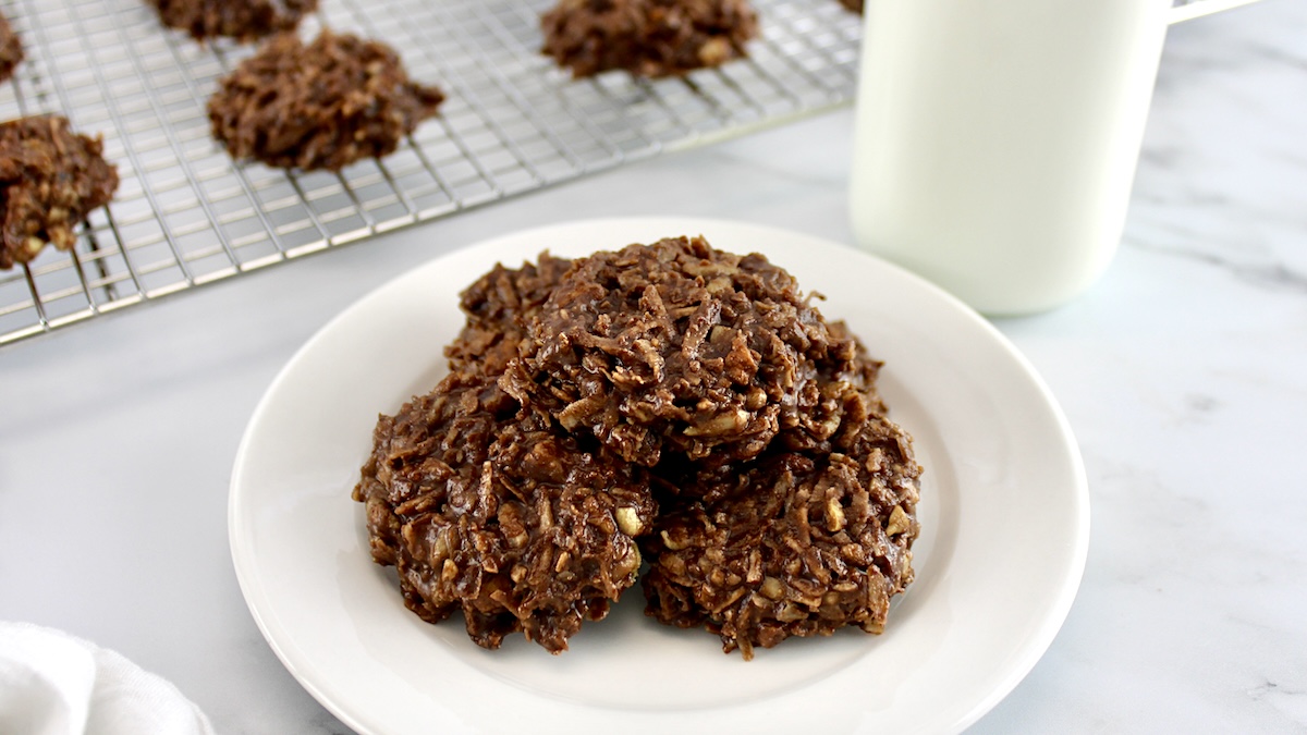 No-Bake Keto Cookies on white round plate with glass milk bottle in back