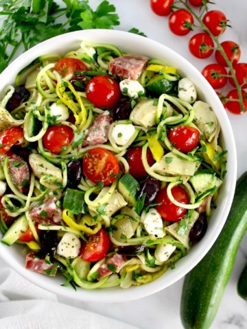 Zucchini Noodle Pasta Salad in white bowl with veggies all around