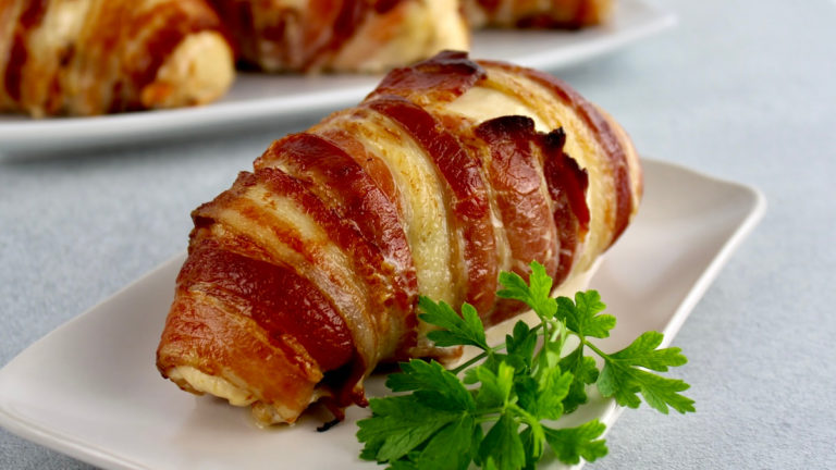 Bacon Wrapped Jalapeño Popper Chicken on white plate with parsley garnish