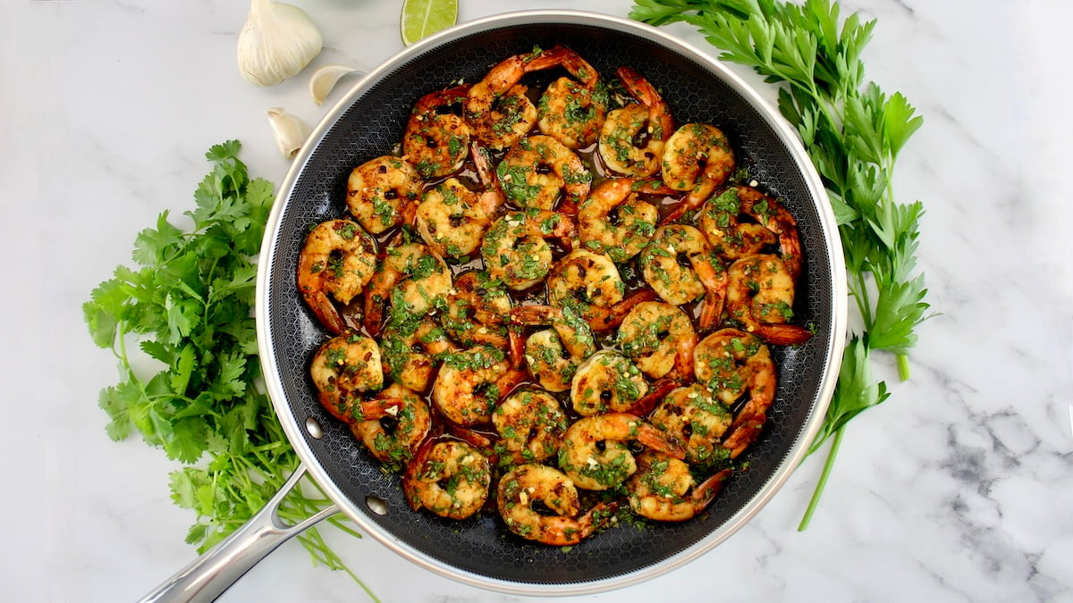 Chimichurri Shrimp in skillet with herbs around