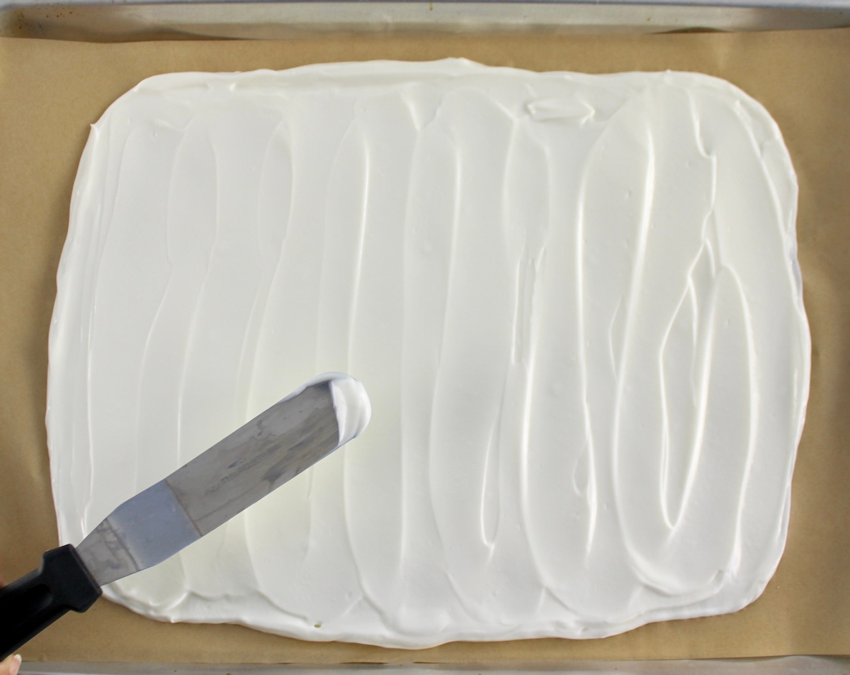 yogurt spread out on parchment lined baking sheet with offset spatula