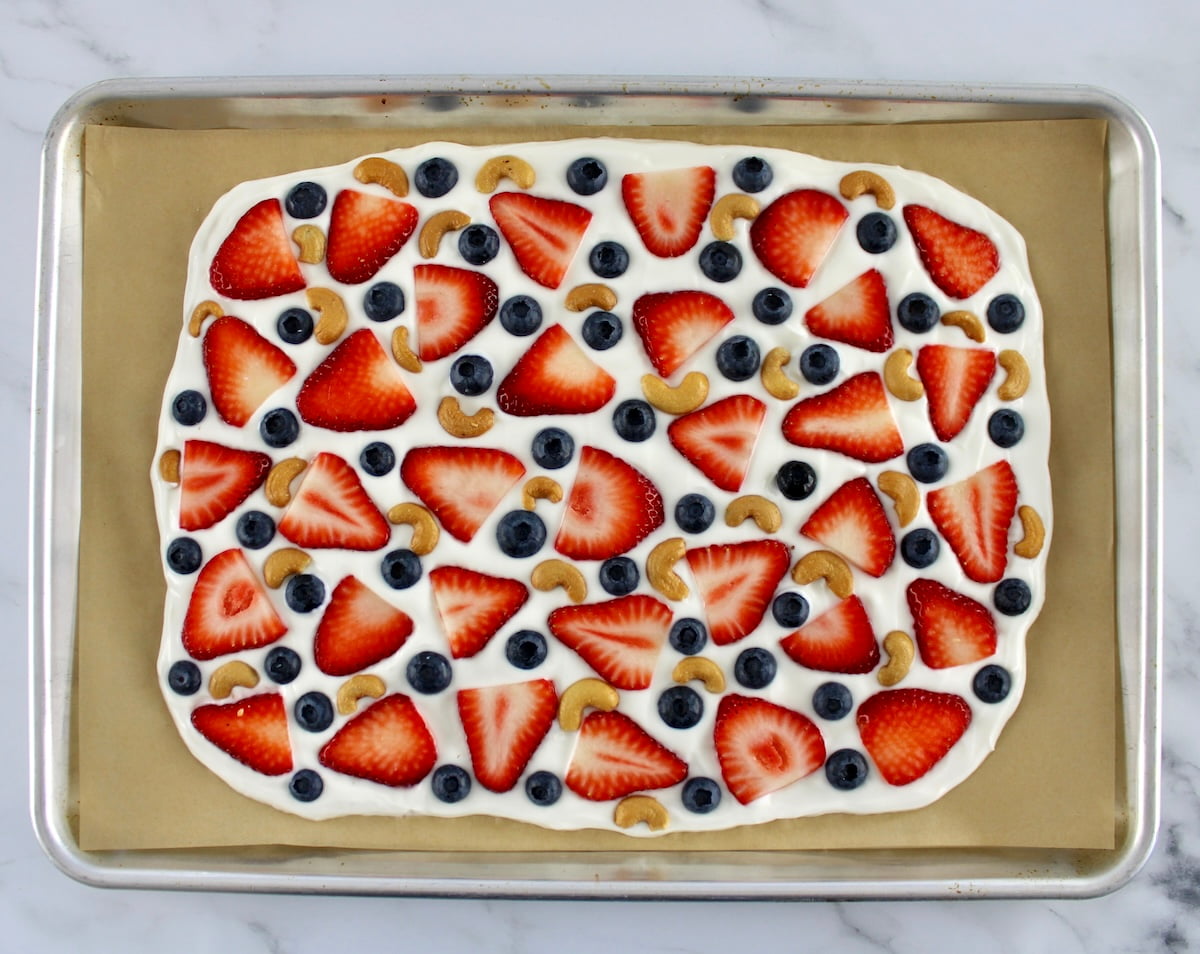 Frozen Yogurt Berry Bark on baking sheet with parchment paper unfrozen