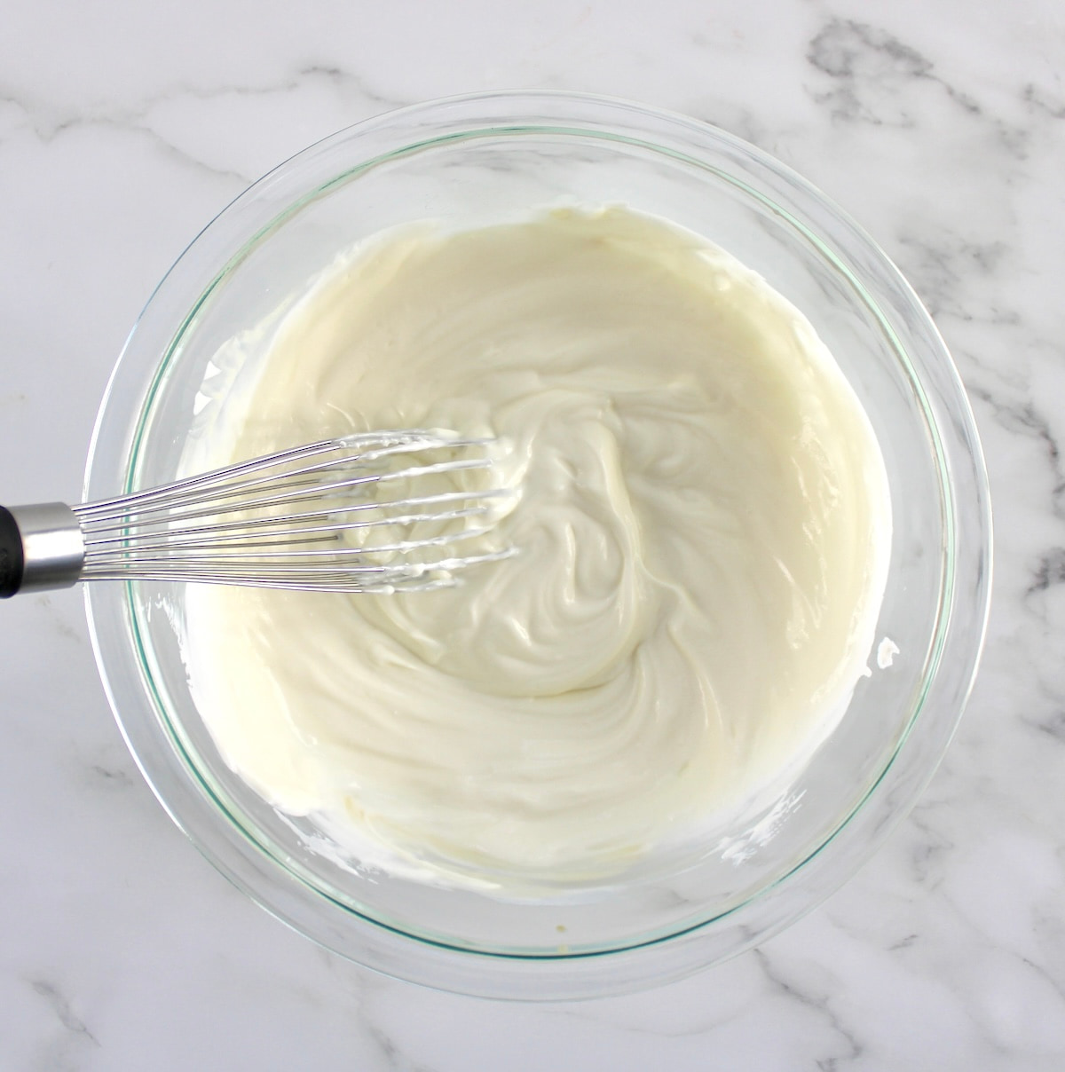 yogurt in glass bowl with whisk