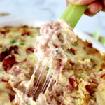 Hot Reuben Dip being dipped with celery stick