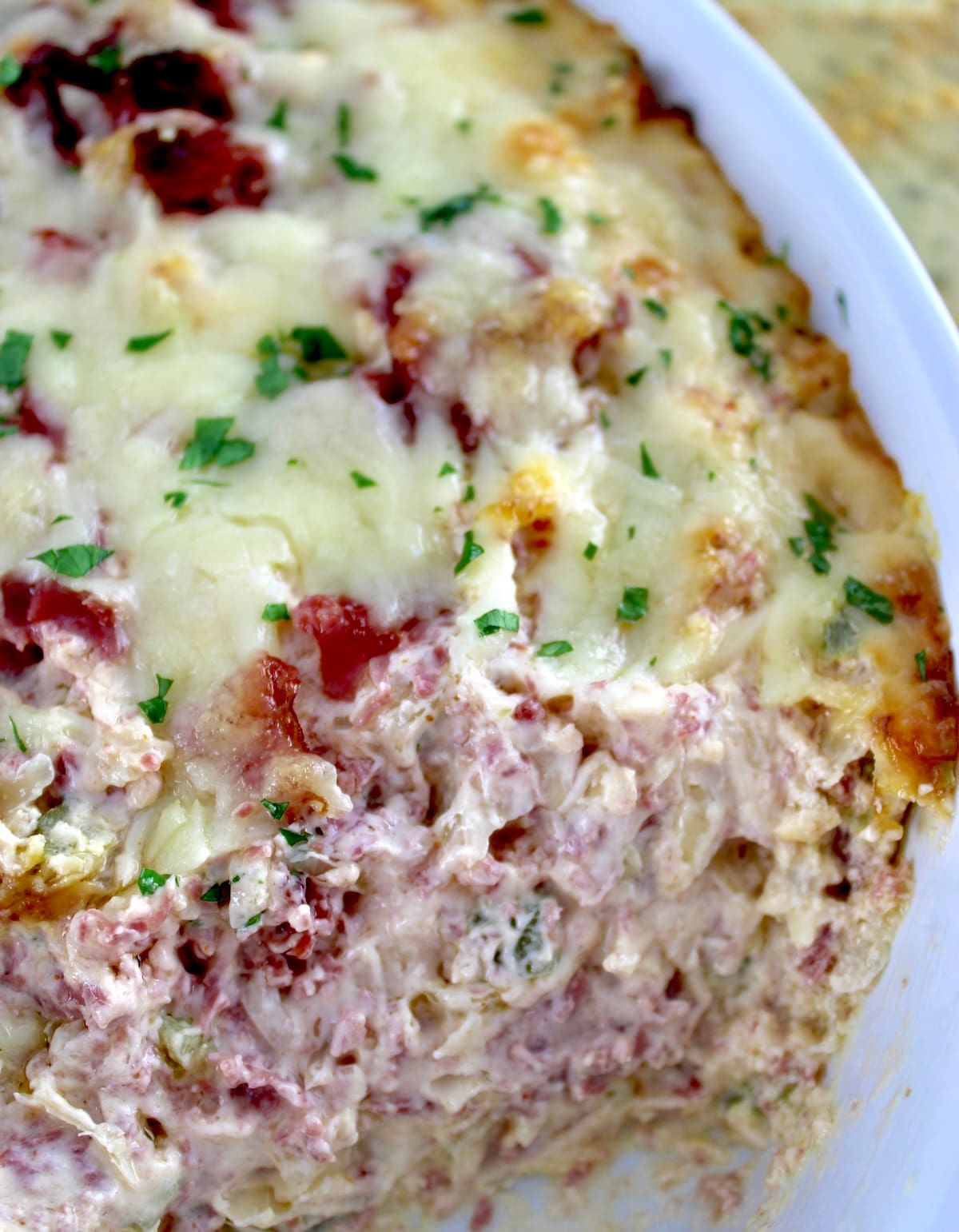 closeup of Hot Reuben Dip in white casserole with some missing