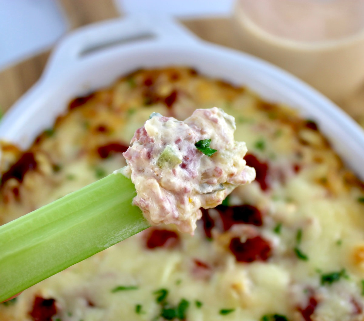 Hot Reuben Dip on end of celery stick held up