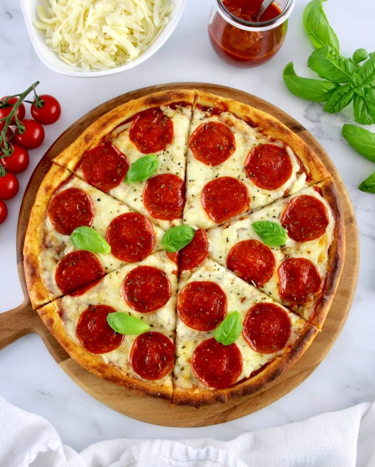 overhead view of Keto Fathead Pizza sliced on wooden round board