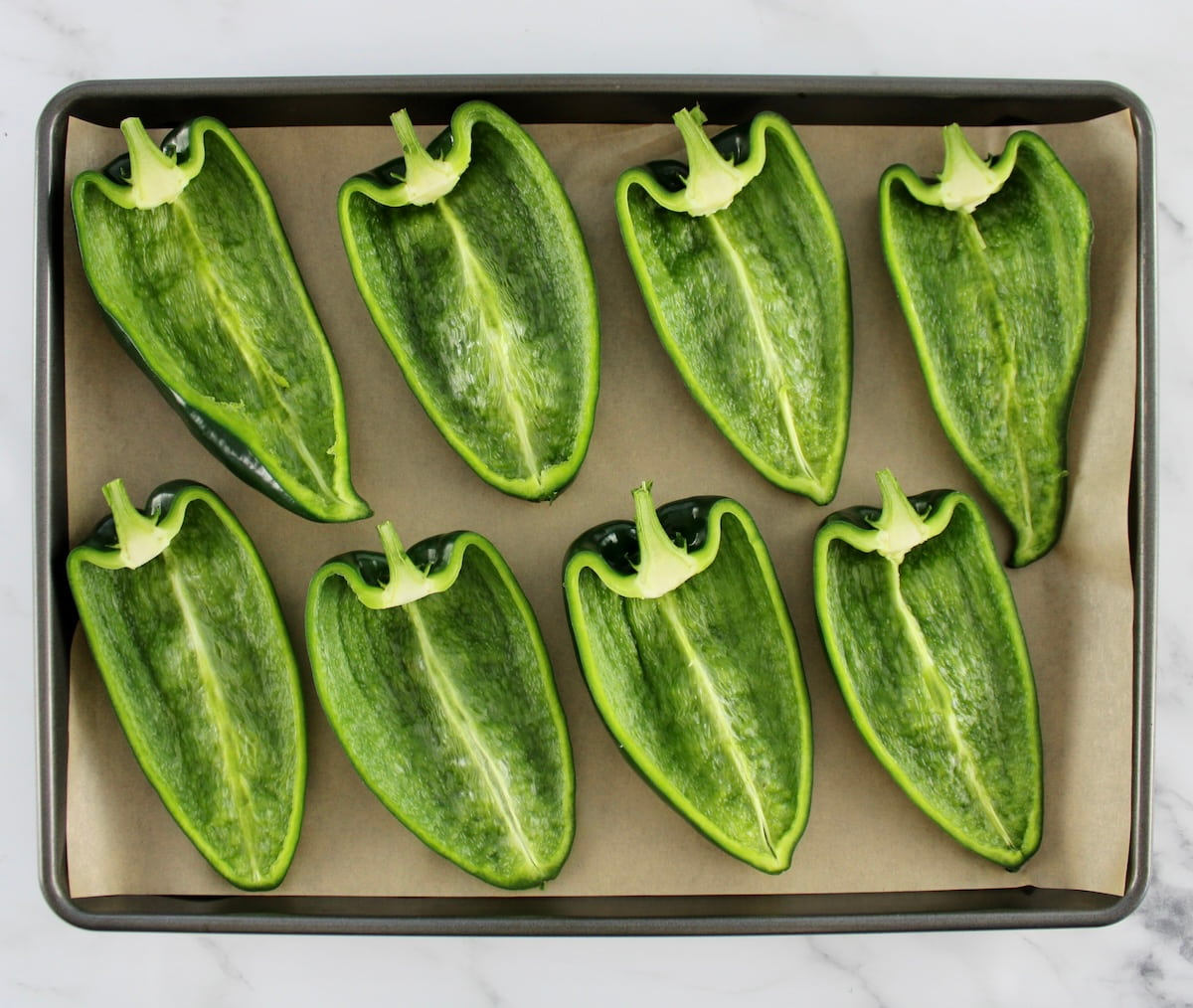 8 poblano halves on parchment lined baking sheet