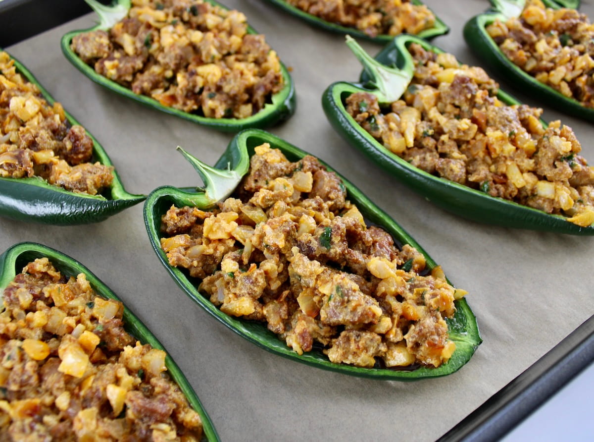 closeup of Stuffed Poblano Peppers on parchment lined baking sheet