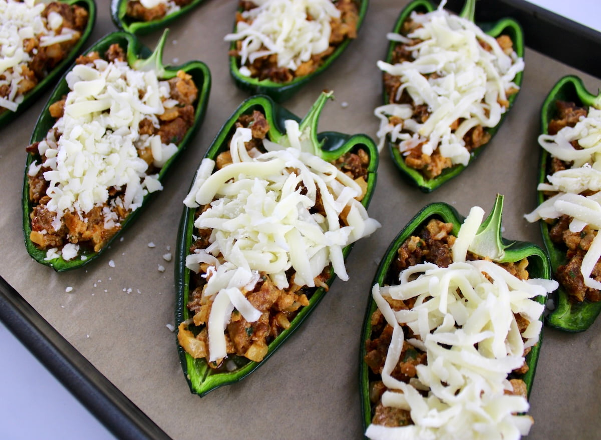 Stuffed Poblano Peppers with shredded mozzarella cheese unbaked on parchment lined baking sheet