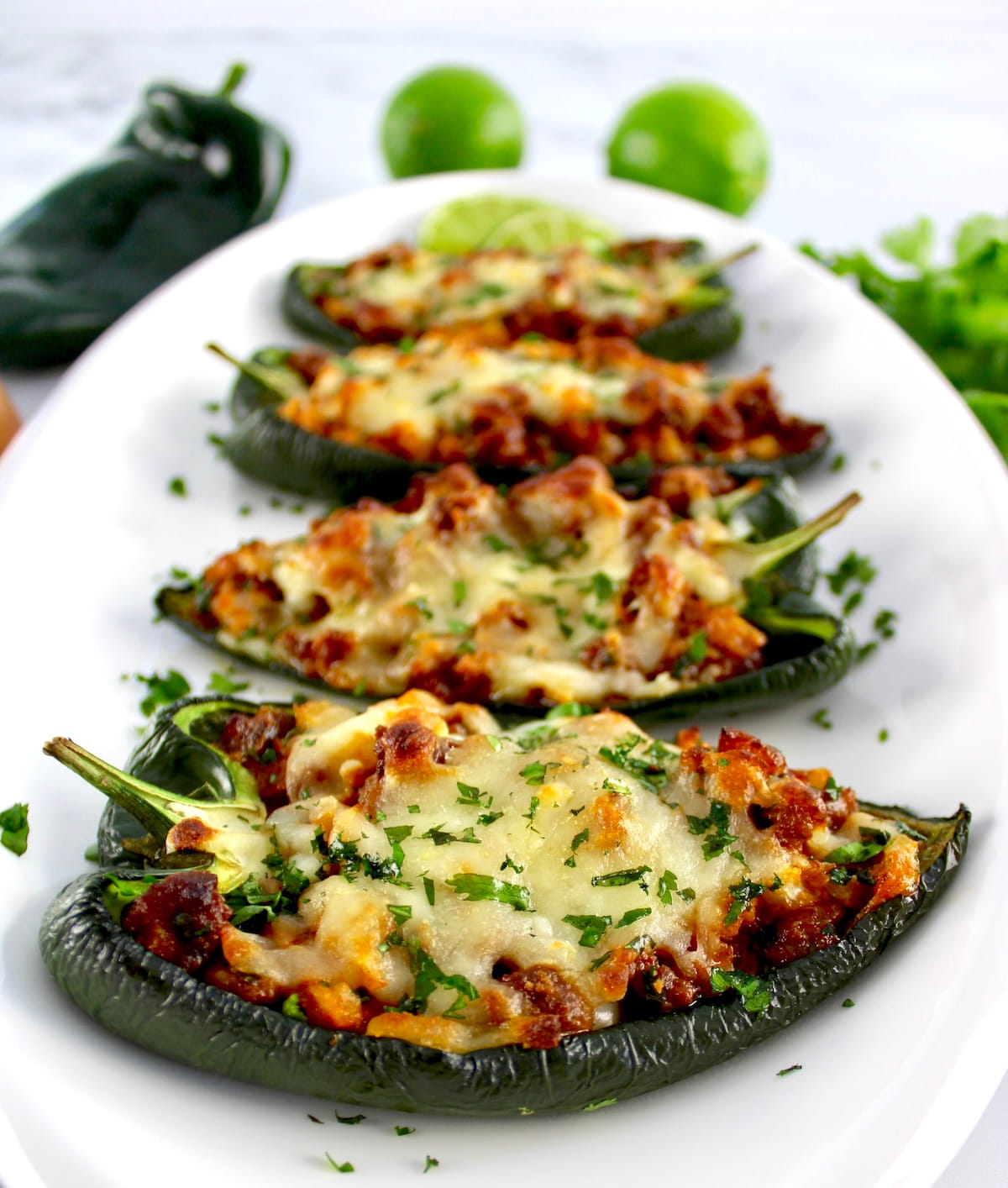 Stuffed Poblano Peppers on white platter lined up