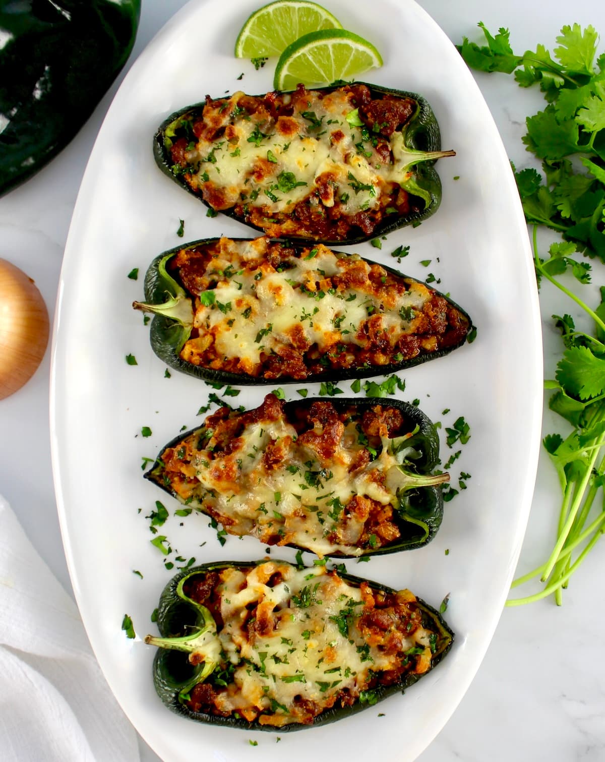 overhead view of 5 Stuffed Poblano Peppers on white oval platter