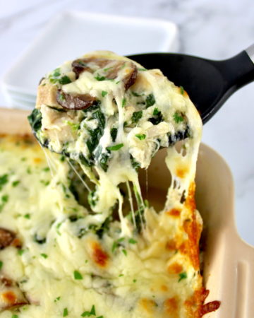 Chicken Alfredo Casserole being scooped out of casserole dish